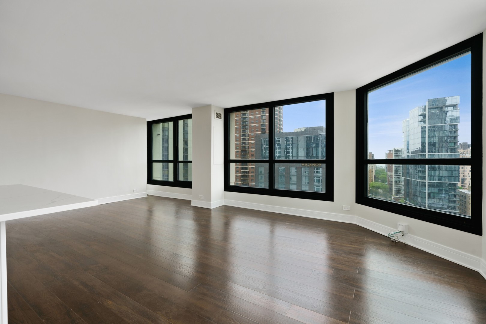 1030 North State Street, Unit 13E Chicago, IL 60610 - Photo 5 of 30 a view of an empty room with wooden floor and a window