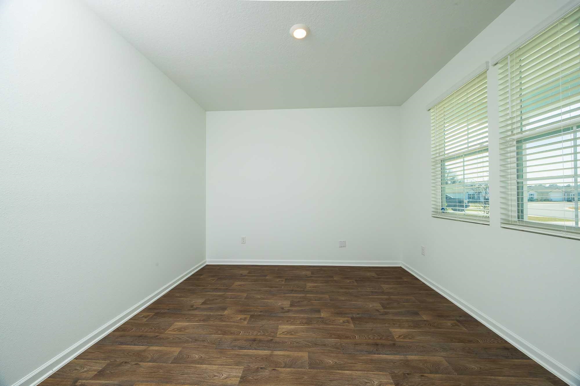 951 Orellana Road St. Augustine, FL 32084 - Photo 13 of 54 an empty room with wooden floor and windows