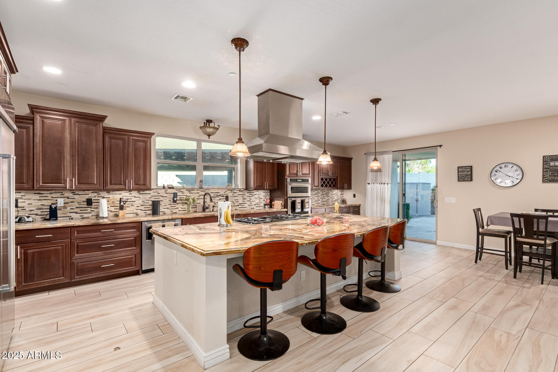 2247 North Beverly Place Buckeye, AZ 85396 - Photo 20 of 95 a kitchen with stainless steel appliances granite countertop a sink a stove and chairs