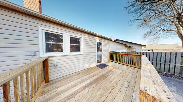 a view of balcony with wooden floor and fence