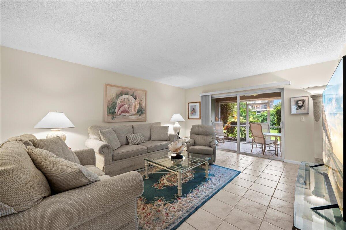 1252 Sugar Sands Boulevard, Unit 137 Riviera Beach, FL 33404 - Photo 12 of 38 a living room with furniture and a table