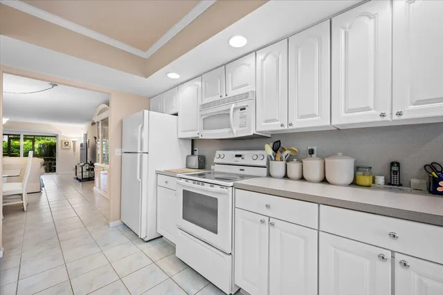 a kitchen with white cabinets and white appliances