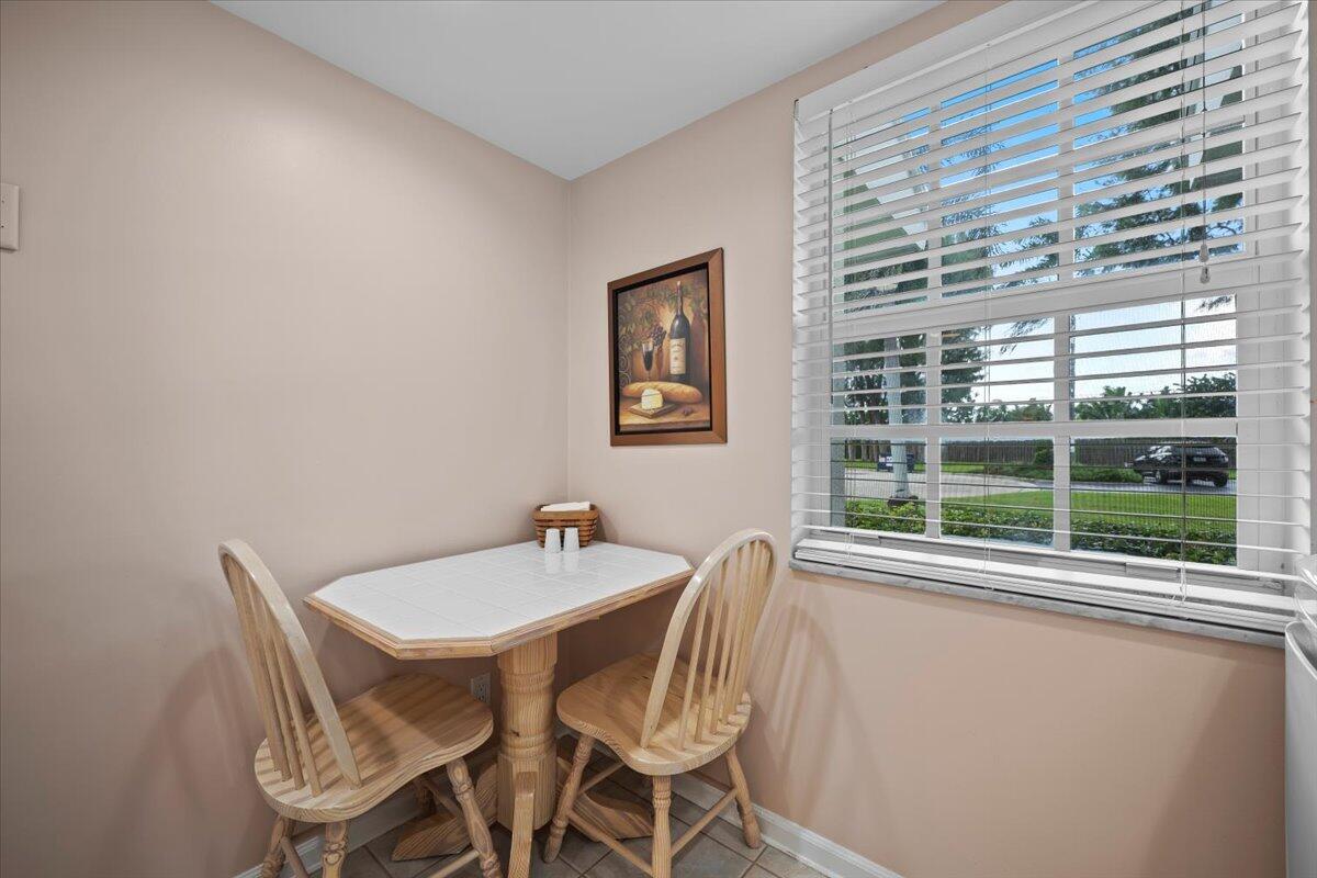 1252 Sugar Sands Boulevard, Unit 137 Riviera Beach, FL 33404 - Photo 16 of 38 a view of a dining room with furniture large windows and a chandelier