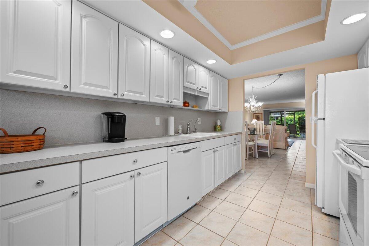 1252 Sugar Sands Boulevard, Unit 137 Riviera Beach, FL 33404 - Photo 17 of 38 a kitchen with white cabinets and sink