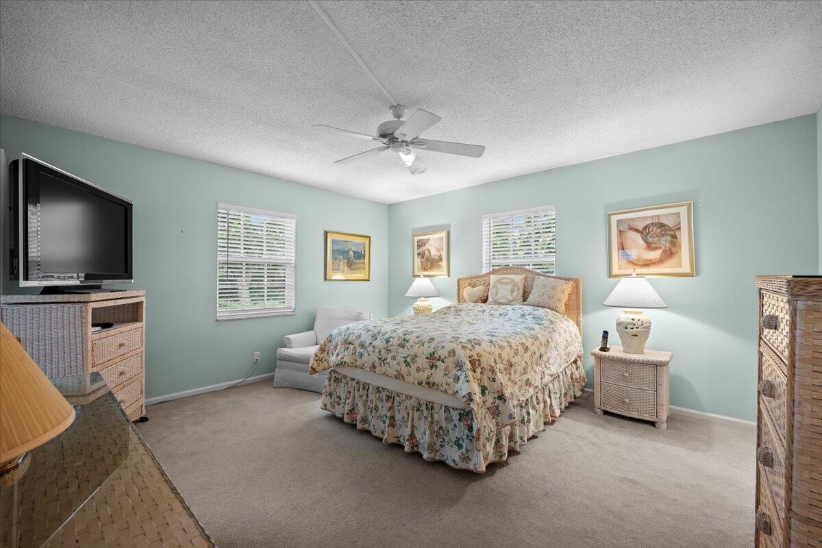1252 Sugar Sands Boulevard, Unit 137 Riviera Beach, FL 33404 - Photo 19 of 38 a bedroom with a bed and a flat screen tv