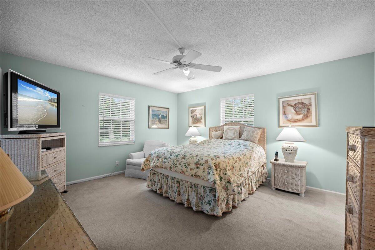 1252 Sugar Sands Boulevard, Unit 137 Riviera Beach, FL 33404 - Photo 20 of 38 a bedroom with a bed and a flat screen tv