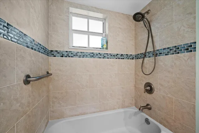 a bathroom with a bath tub with a shower