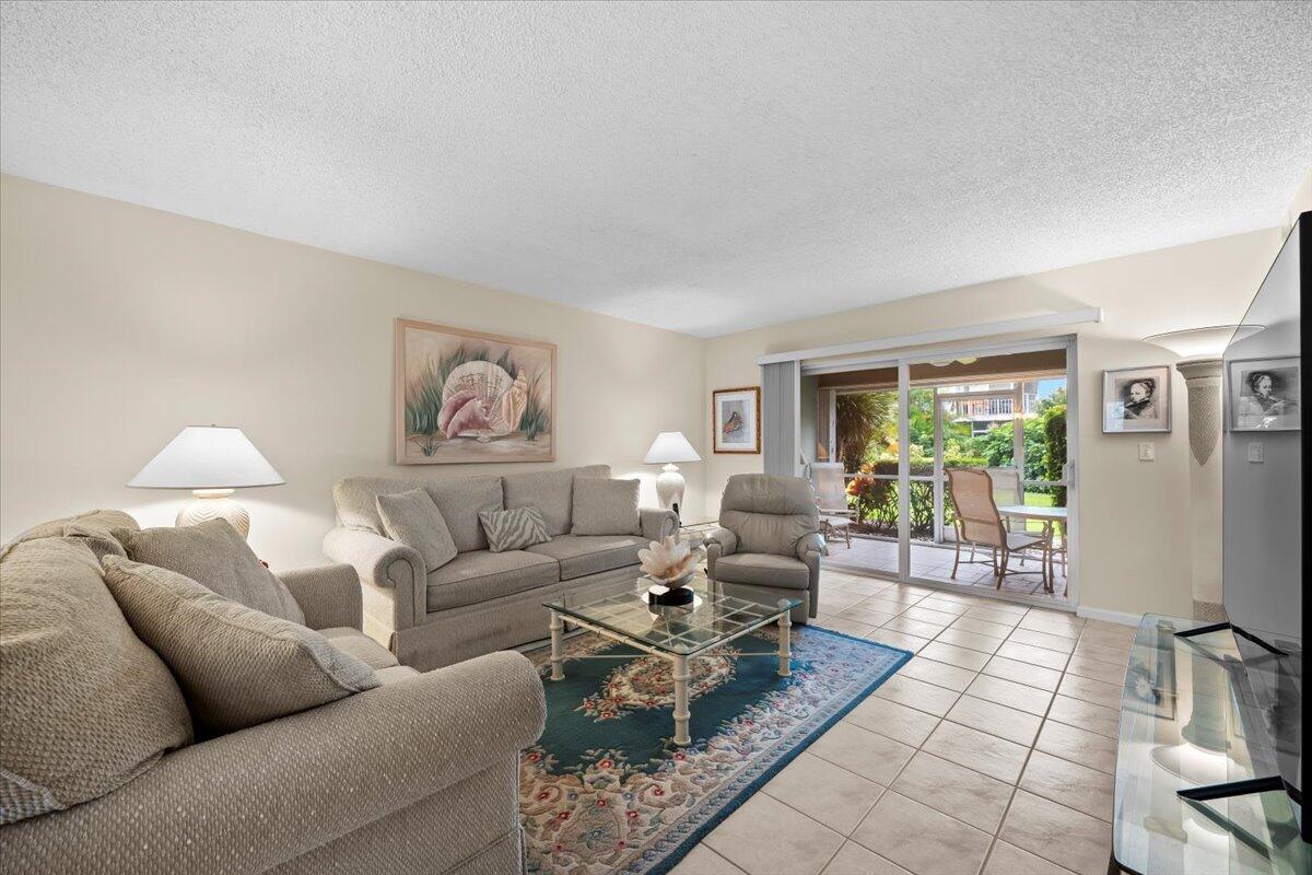 1252 Sugar Sands Boulevard, Unit 137 Riviera Beach, FL 33404 - Photo 3 of 38 a living room with furniture and a table