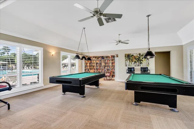 a room with pool table and windows