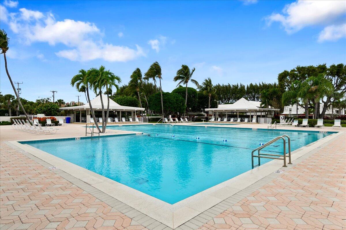 1252 Sugar Sands Boulevard, Unit 137 Riviera Beach, FL 33404 - Photo 35 of 38 a view of swimming pool with outdoor seating and lake in the background