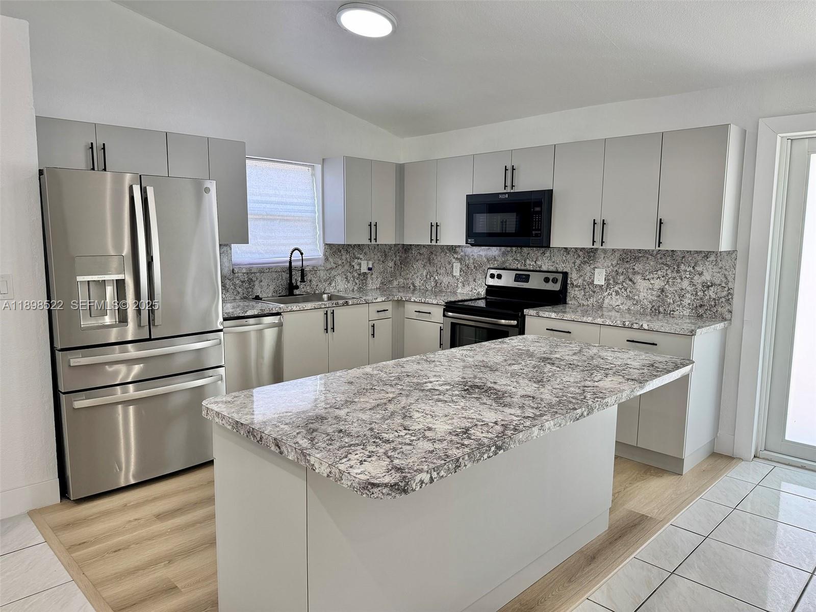 22712 Southwest 113th Place Miami, FL 33170 - Photo 4 of 15 a kitchen with stainless steel appliances granite countertop a refrigerator stove microwave and sink
