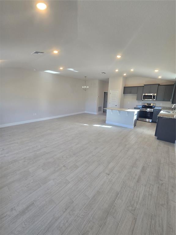 423 Wood Stork Trail Inverness, FL 34453 - Photo 12 of 19 a view of a kitchen with kitchen island a sink wooden floor and a counter top space