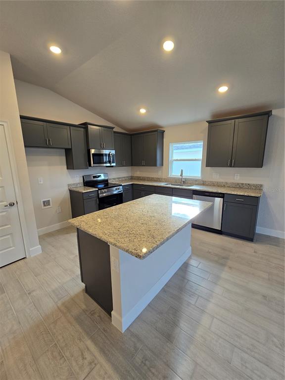 423 Wood Stork Trail Inverness, FL 34453 - Photo 13 of 19 a spacious kitchen with stainless steel appliances granite countertop a stove a sink dishwasher and a refrigerator