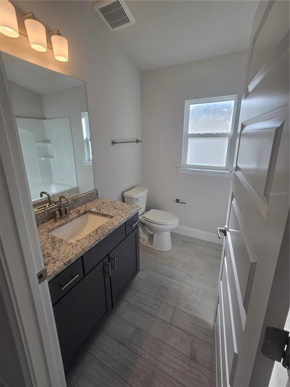 423 Wood Stork Trail Inverness, FL 34453 - Photo 10 of 19 a bathroom with a granite countertop sink toilet and mirror