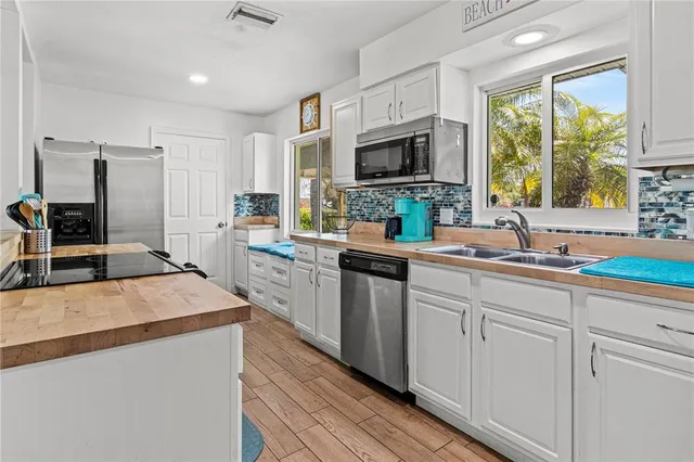 a kitchen with stainless steel appliances a sink stove and cabinets