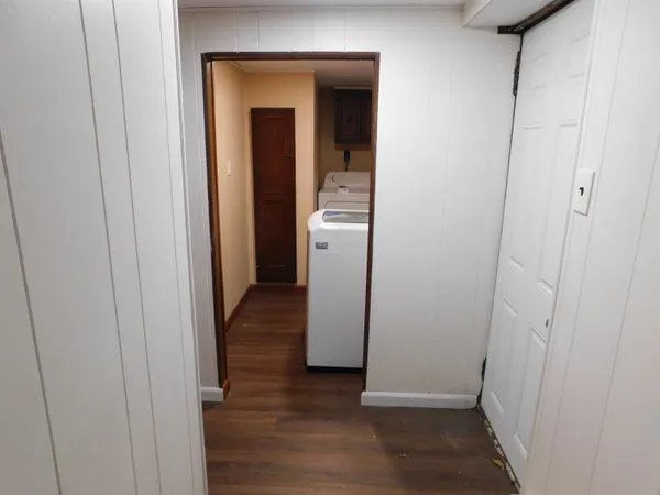 a view of a hallway with wooden floor and closet