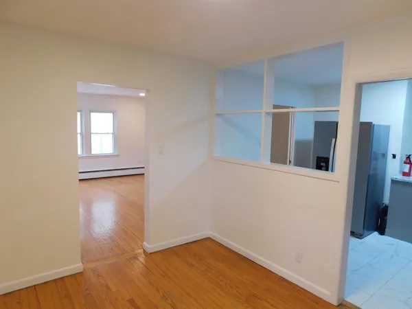 a view of empty room with wooden floor