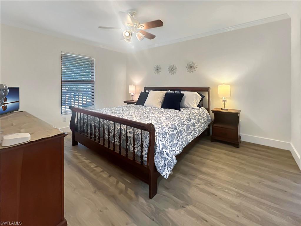 600 Neapolitan Way, Unit 342 Naples, FL 34103 - Photo 11 of 50 a bedroom with bed and a chandelier