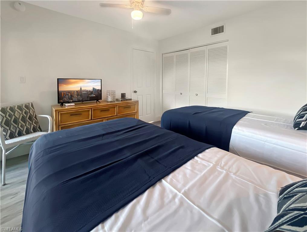 600 Neapolitan Way, Unit 342 Naples, FL 34103 - Photo 22 of 50 a bedroom with two beds and a flat screen tv