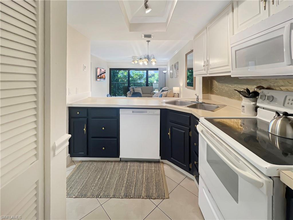 600 Neapolitan Way, Unit 342 Naples, FL 34103 - Photo 3 of 50 a kitchen with a sink stove and cabinets