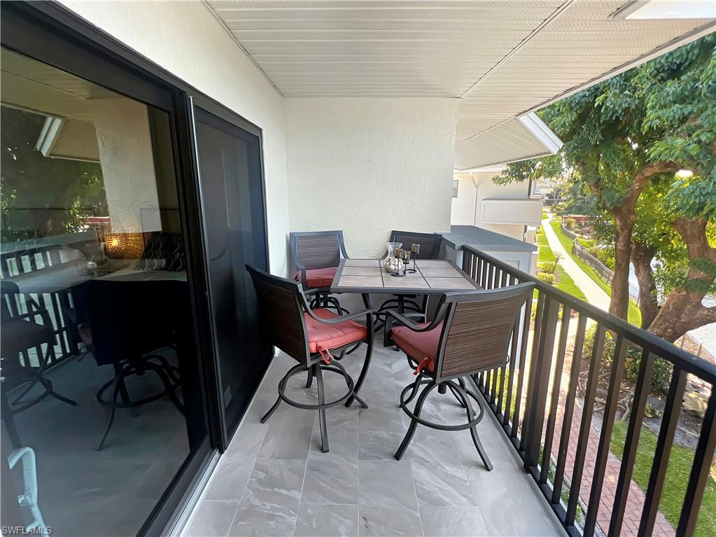 600 Neapolitan Way, Unit 342 Naples, FL 34103 - Photo 34 of 50 a view of a porch with furniture and a yard