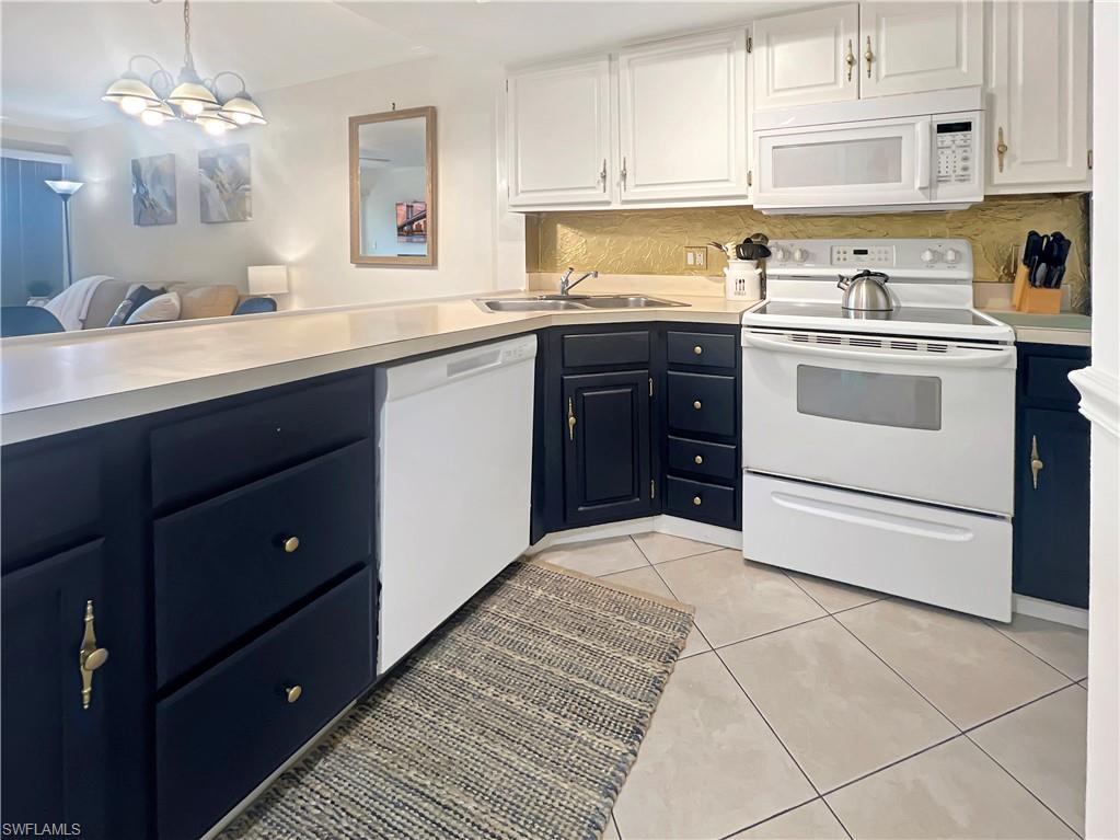 600 Neapolitan Way, Unit 342 Naples, FL 34103 - Photo 5 of 50 a kitchen with a sink a stove and cabinets