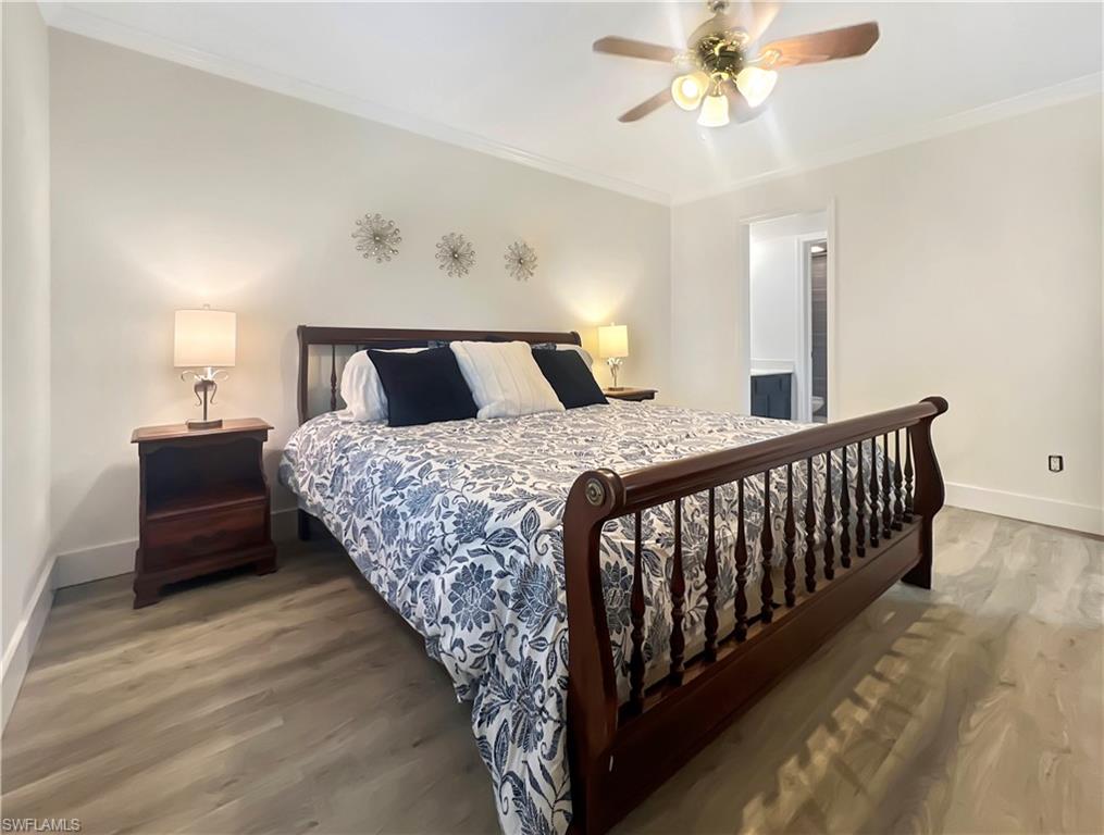 600 Neapolitan Way, Unit 342 Naples, FL 34103 - Photo 8 of 50 a bedroom with a bed and a chandelier