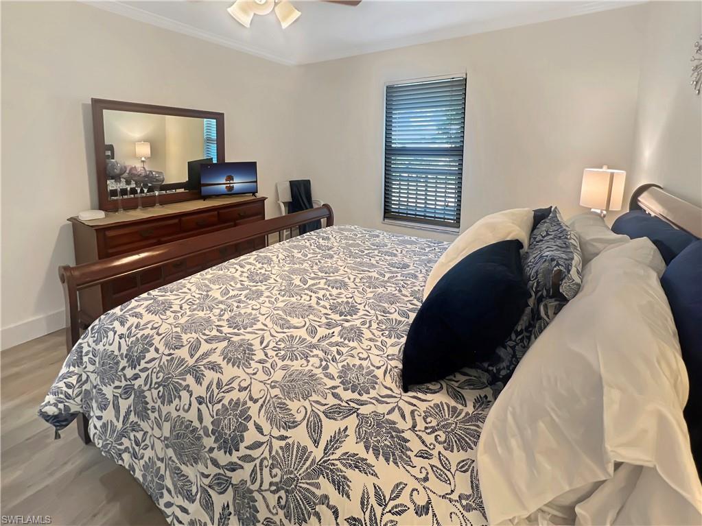 600 Neapolitan Way, Unit 342 Naples, FL 34103 - Photo 9 of 50 a bedroom with a bed and a television
