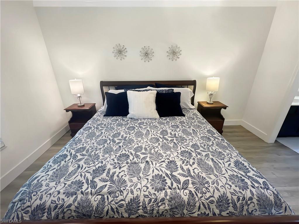 600 Neapolitan Way, Unit 342 Naples, FL 34103 - Photo 10 of 50 a large bed sitting in a bedroom next to a window