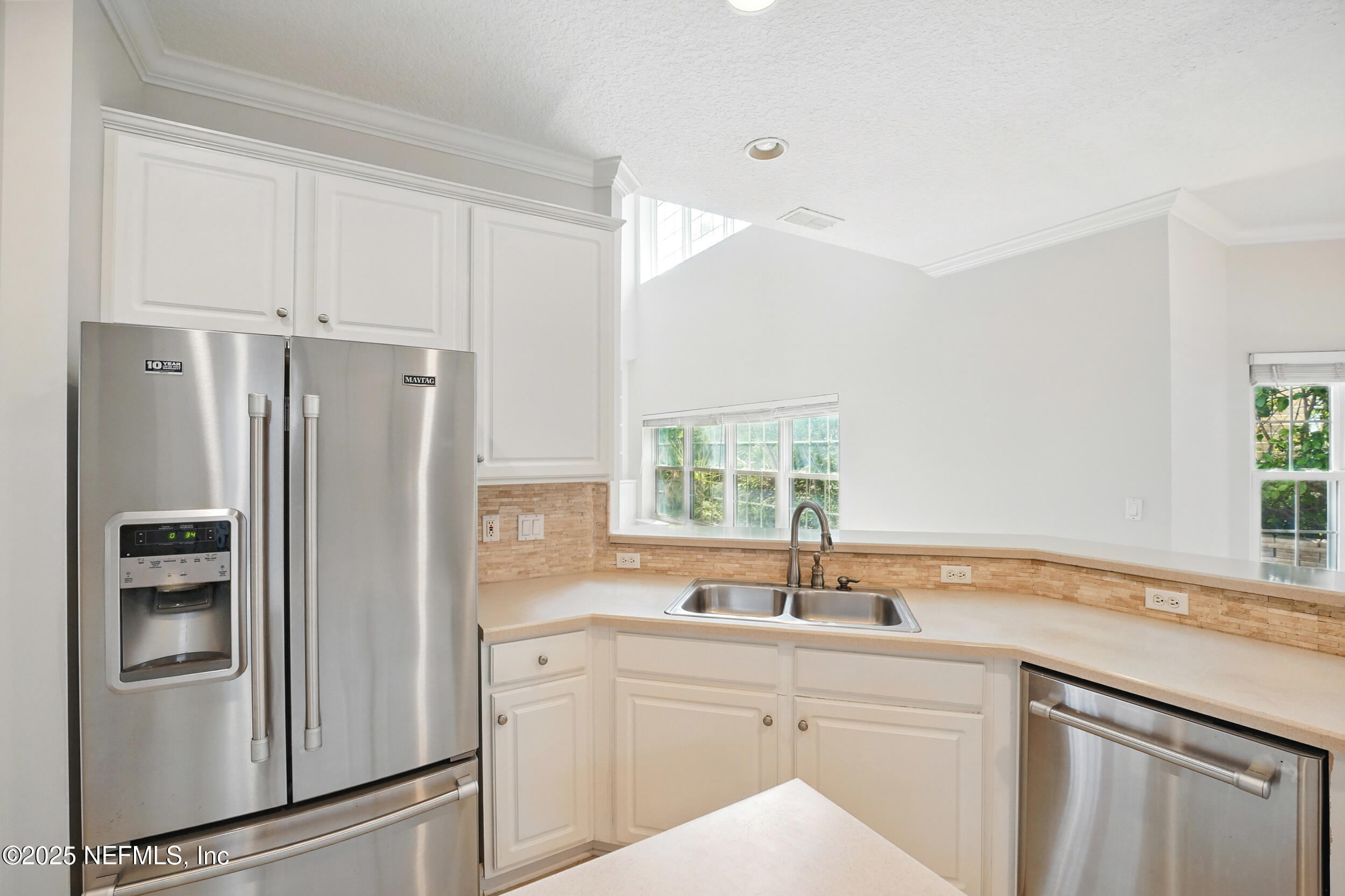 105 2nd Street St. Augustine, FL 32084 - Photo 21 of 61 a kitchen with stainless steel appliances a refrigerator sink and cabinets