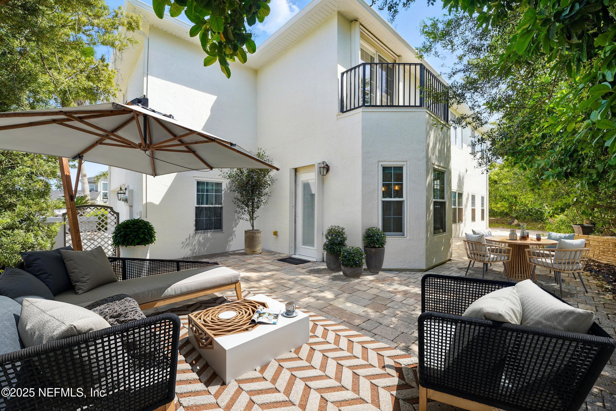 105 2nd Street St. Augustine, FL 32084 - Photo 47 of 61 a view of a patio with couches table and chairs under an umbrella