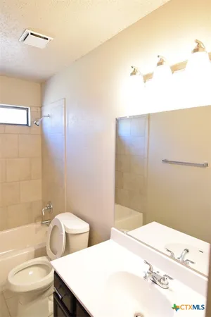 a bathroom with a sink and mirror with toilet
