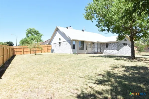 a view of house with backyard and tree
