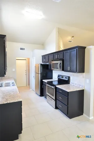 a kitchen with granite countertop a stove and a sink