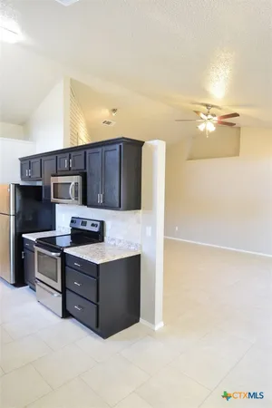 a kitchen with stainless steel appliances a stove refrigerator and microwave