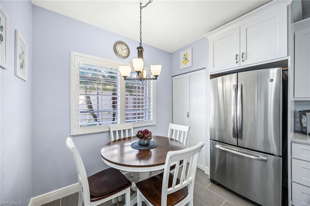 9022 Michael Circle, Unit 3 Naples, FL 34113 - Photo 16 of 29 a kitchen with stainless steel appliances granite countertop a dining table chairs and chandelier