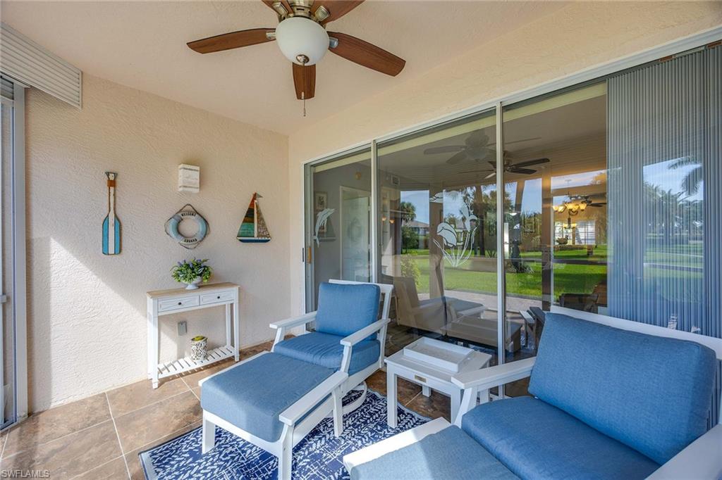 9022 Michael Circle, Unit 3 Naples, FL 34113 - Photo 25 of 29 a living room with furniture and a floor to ceiling window