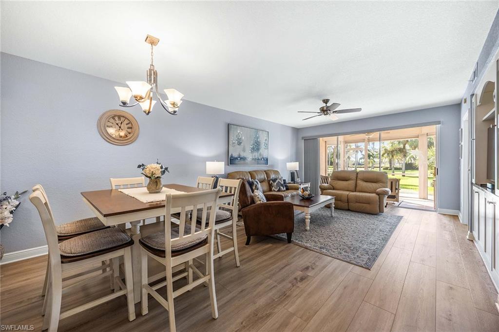 9022 Michael Circle, Unit 3 Naples, FL 34113 - Photo 6 of 29 a view of a dining room and livingroom with furniture wooden floor a chandelier