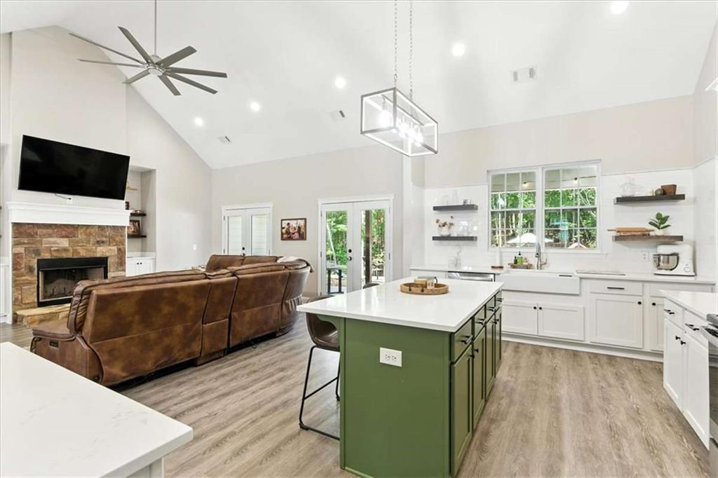 62 Joe Rowell Road Buchanan, GA 30113 - Photo 15 of 63 a kitchen with a stove a sink a kitchen island with chairs and wooden floor