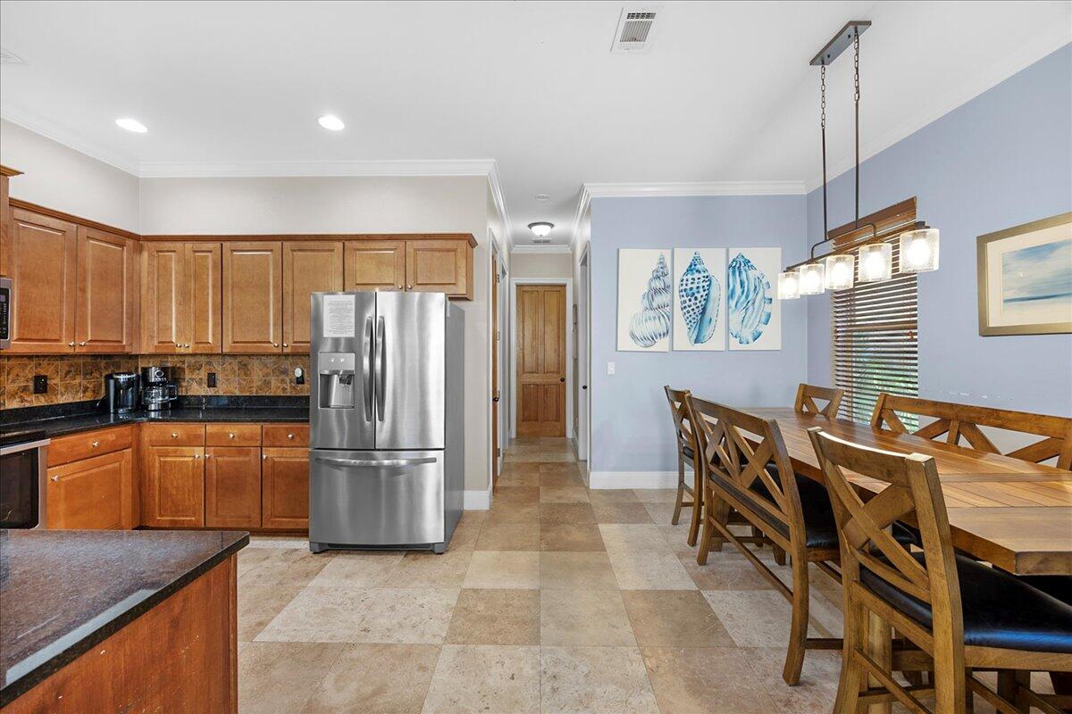 210 Grand Key Loop West Destin, FL 32541 - Photo 37 of 46 a kitchen with stainless steel appliances granite countertop a refrigerator a stove a sink a dining table and chairs with wooden floor