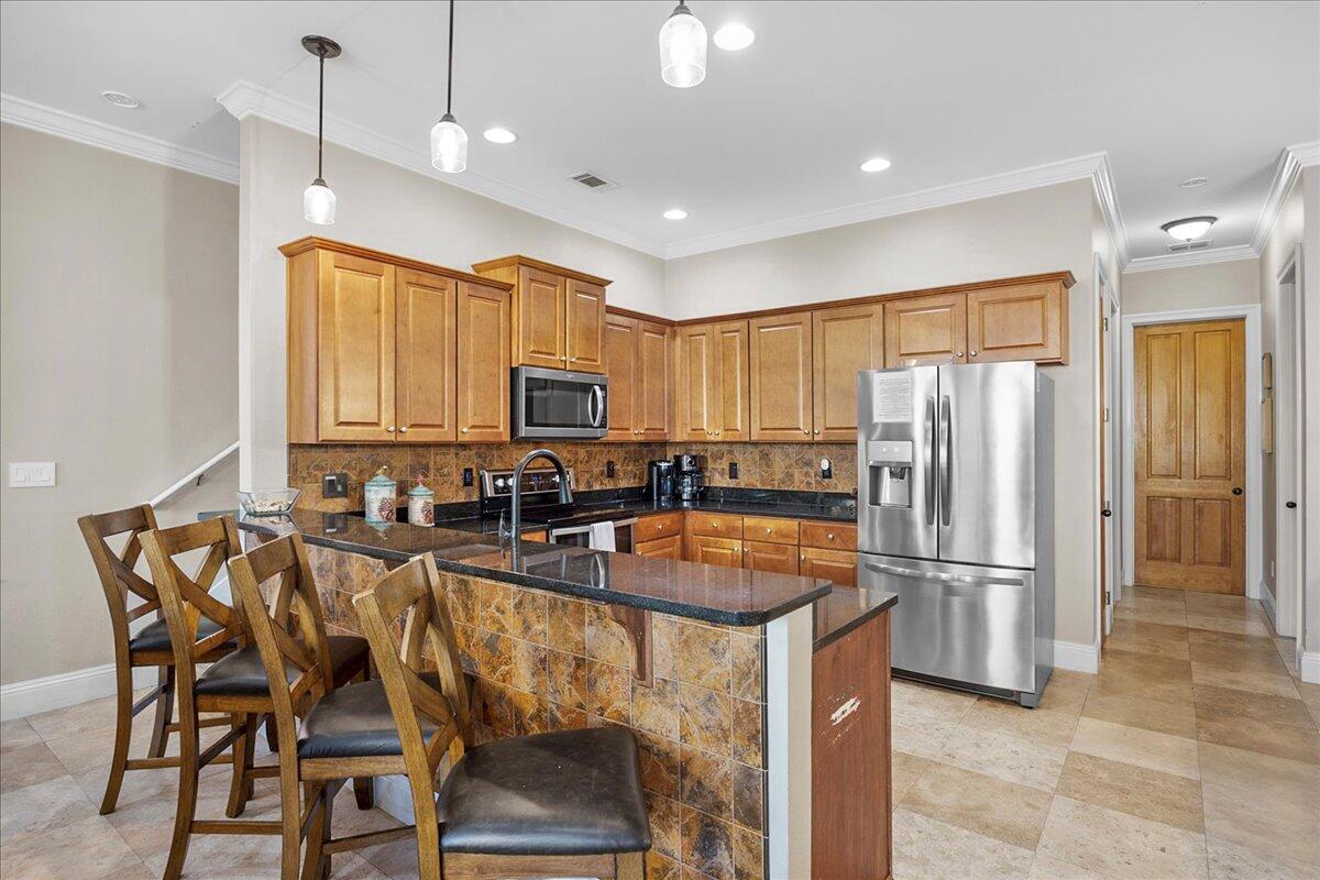 210 Grand Key Loop West Destin, FL 32541 - Photo 44 of 46 a kitchen with sink a refrigerator and chairs