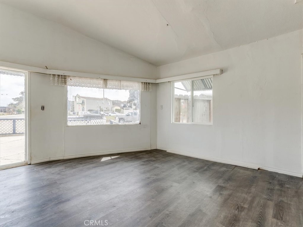 396 Pier Avenue Oceano, CA 93445 - Photo 15 of 24 an empty room with wooden floor and windows