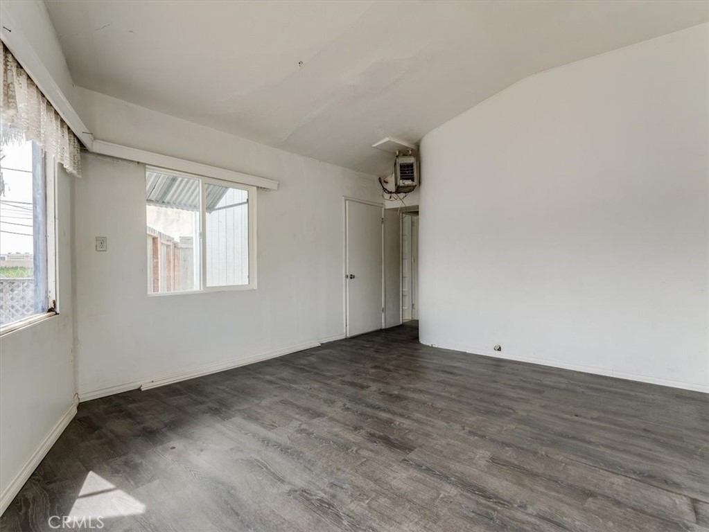 396 Pier Avenue Oceano, CA 93445 - Photo 16 of 24 an empty room with wooden floor and windows