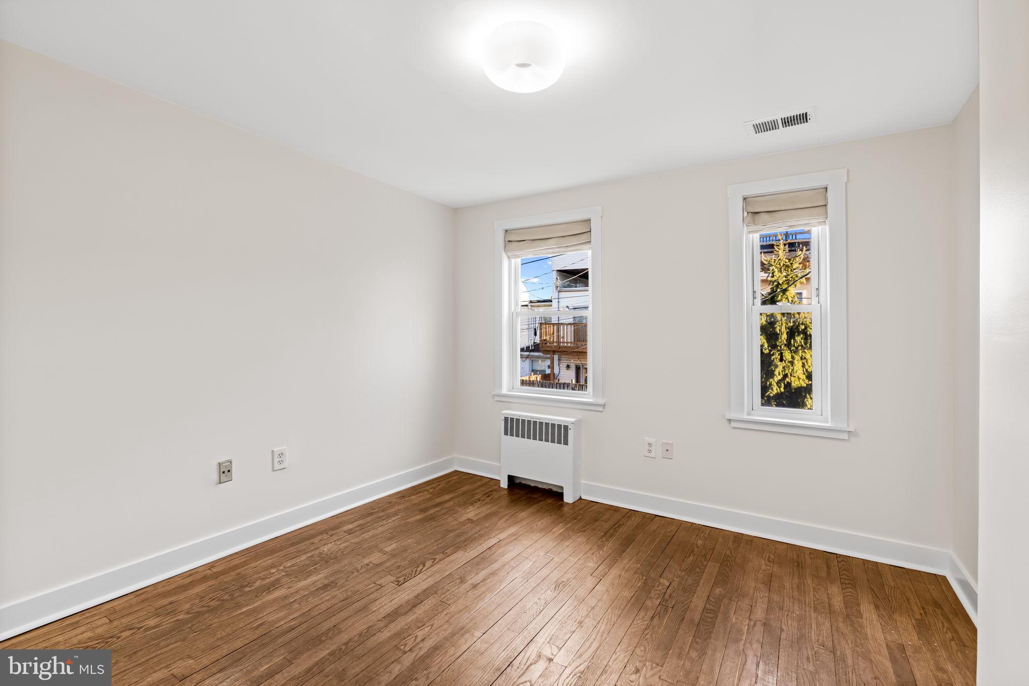 1459 Woodall Street Baltimore, MD 21230 - Photo 27 of 34 an empty room with wooden floor and windows