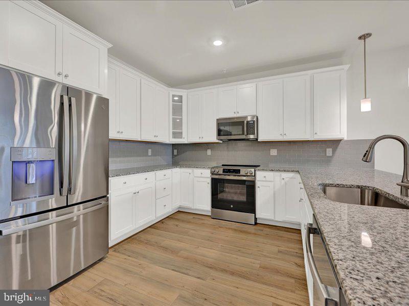 4005 Seaside Alder Road, Unit D Bowie, MD 20720 - Photo 8 of 41 a kitchen with stainless steel appliances granite countertop a refrigerator sink and stove