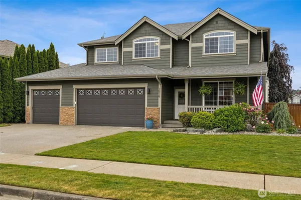 a front view of a house with a yard and garage