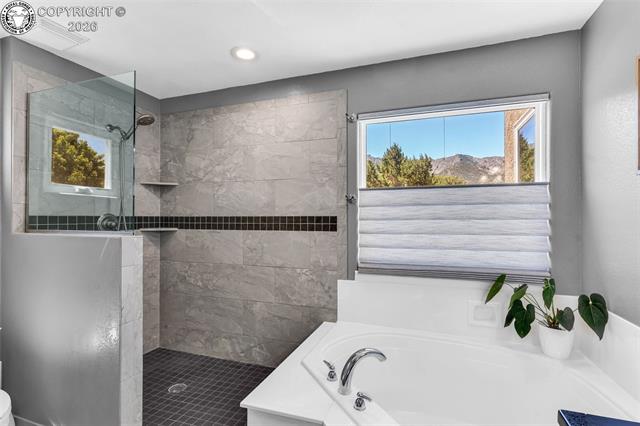 182 Raptor Court Canon City, CO 81212 - Photo 15 of 50 A large window fills the space with natural sunlight, enhancing the open and airy feel, while the electric blinds over the tub can be controlled by remote or app for added convenience and privacy.
