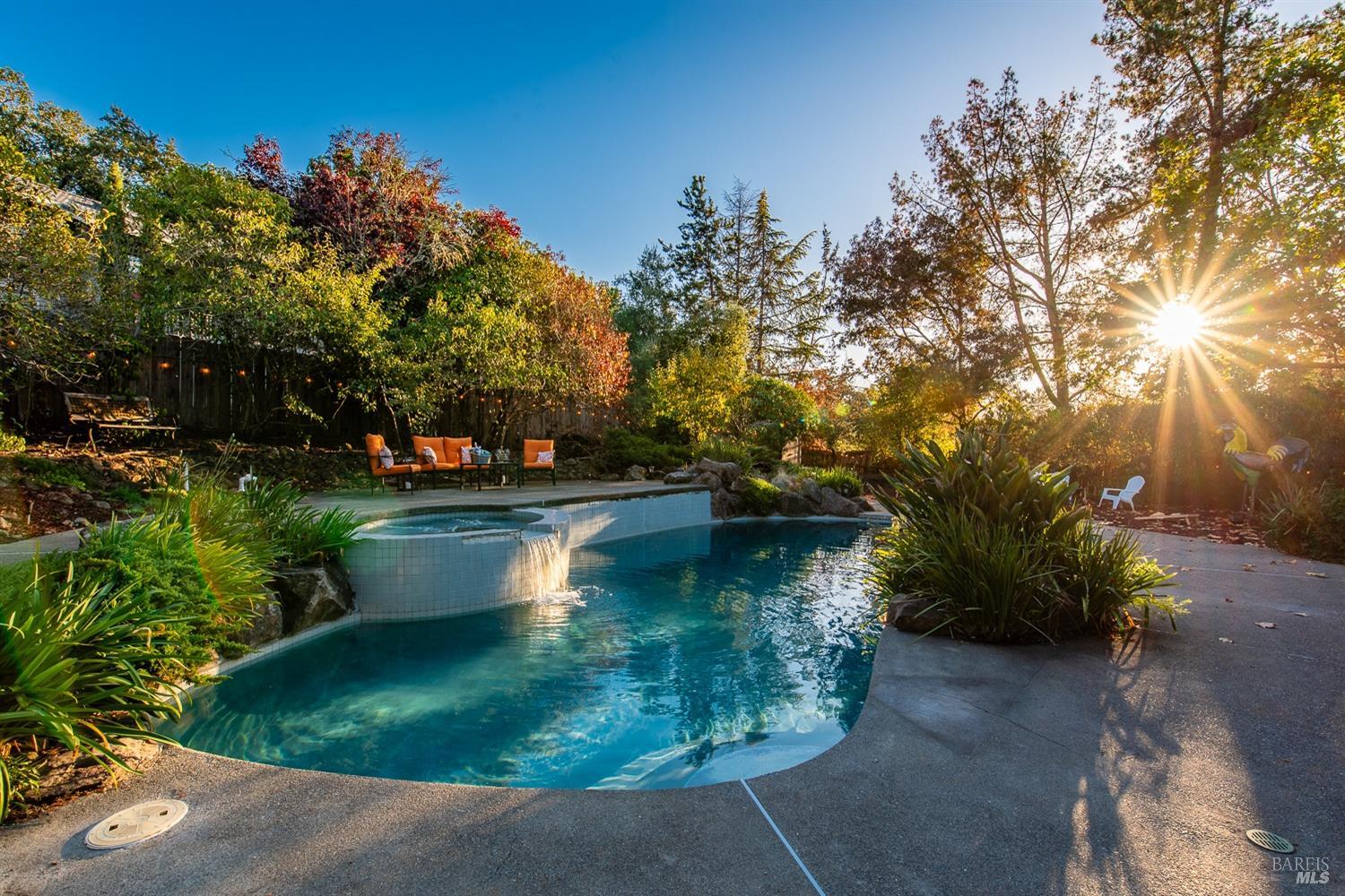 Entertaining is a dream on this private .48 acre lot. Primary suite is located on the ground level with view of the pool with waterfall. Enjoy the sunset from your own backyard.
