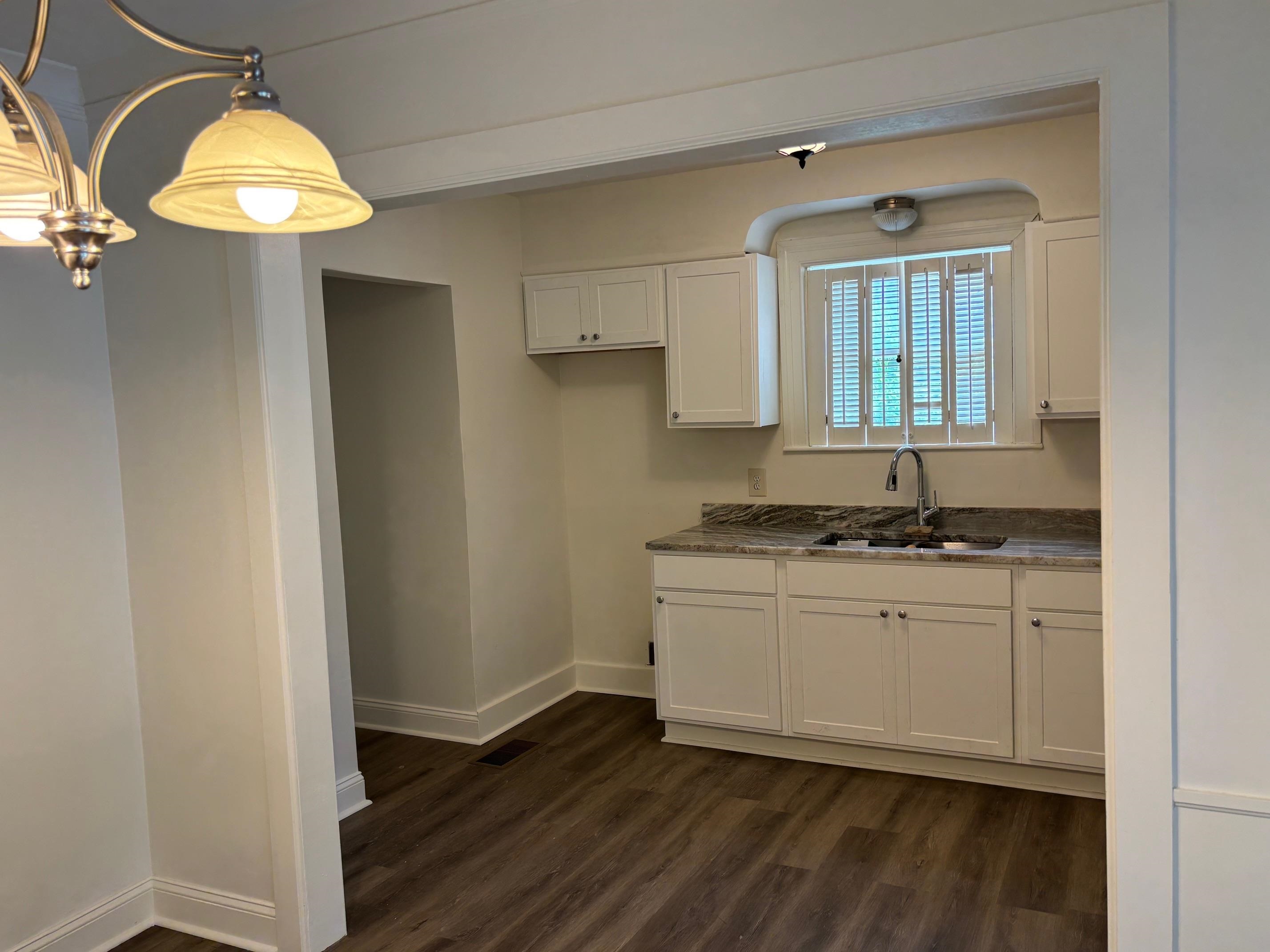 3750 Kearney Avenue Memphis, TN 38111 - Photo 11 of 14 a kitchen with granite countertop a sink cabinets and a wooden floor