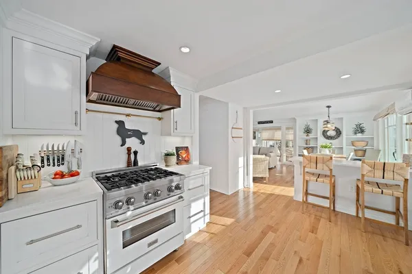 a large kitchen with cabinets wooden floor and stainless steel appliances